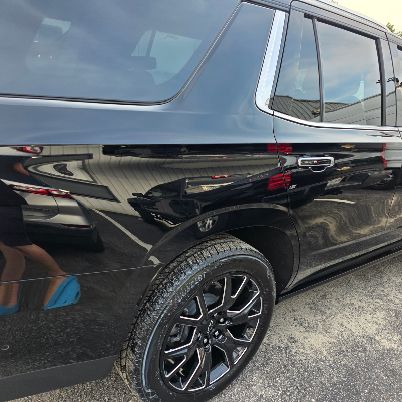 Mirror-deep gloss reflection on a corrected black SUV